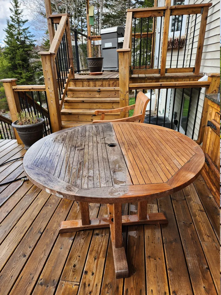 Wood patio table partially cleaned to show the difference between weathered and refreshed wood