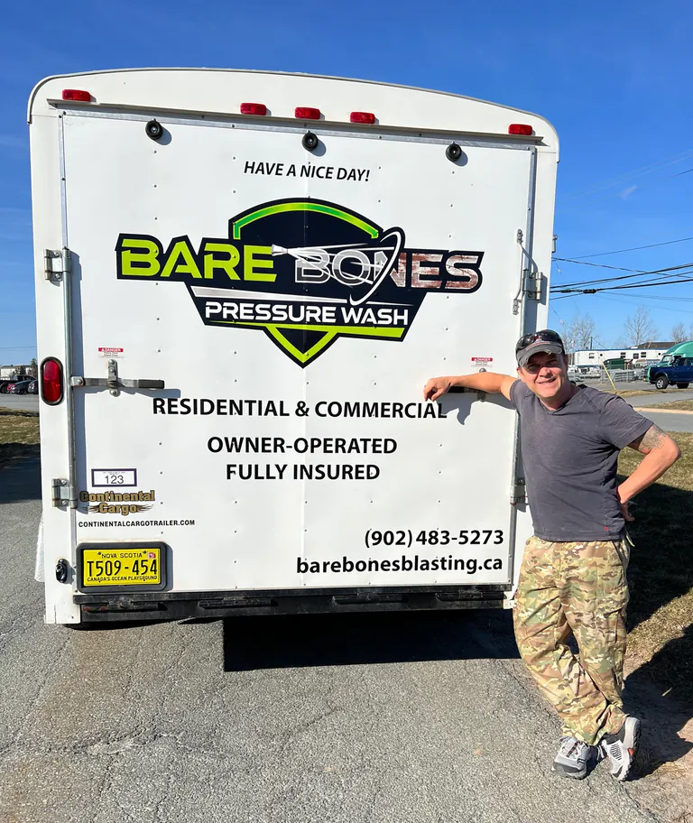 Peter, owner of Bare Bones Pressure Wash, standing beside his branded service trailer