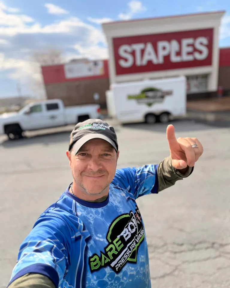 Peter in Bare Bones workwear with his truck and service trailer outside Staples