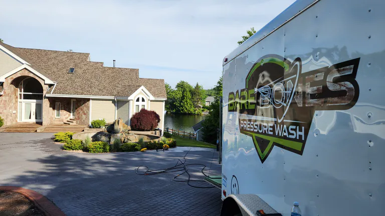 Bare Bones Pressure Wash service trailer set up at a landscaped residential property