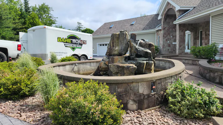 Bare Bones Pressure Wash service trailer outside a residential property with stone landscaping